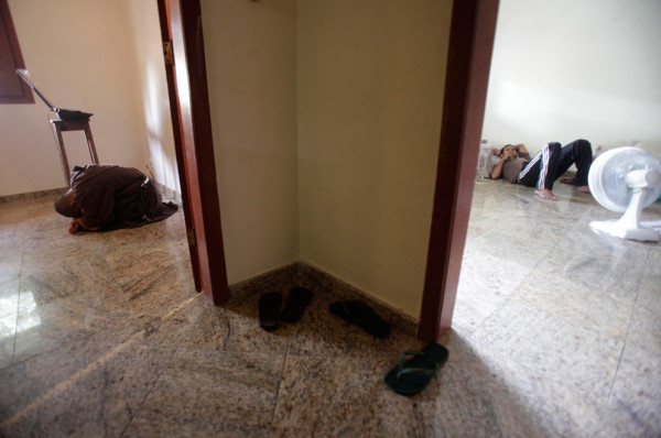 Брат Пласидо (слева) молится в часовне дома братства, а один из претендентов отдыхает в другой комнате. Фото: Ricardo Moraes/Reuters (BRAZIL)