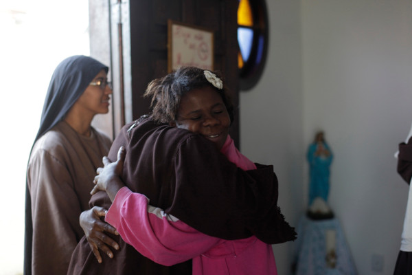 Элейн дос Сантос (справа), бездомная, которая живет вместе с братством, обнимает монахиню после утренней молитвы в Кампо Гранде. Фото: Ricardo Moraes/Reuters (BRAZIL)